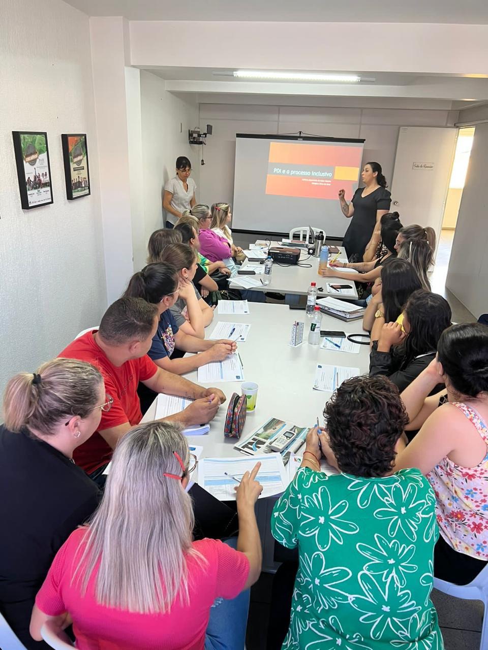 Participantes acompanham a formação com materiais impressos sobre a mesa